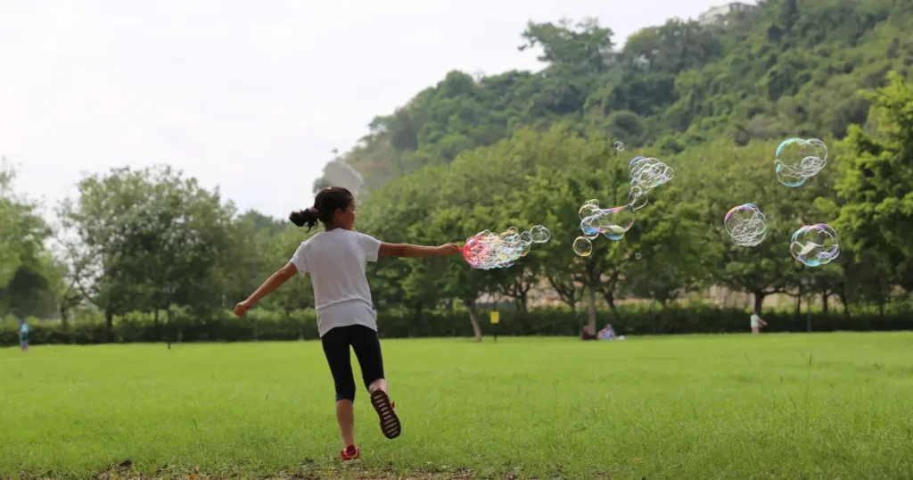 Child running through a park with bubbles — illustrative outdoor play for all inclusive family resorts on the east coast.