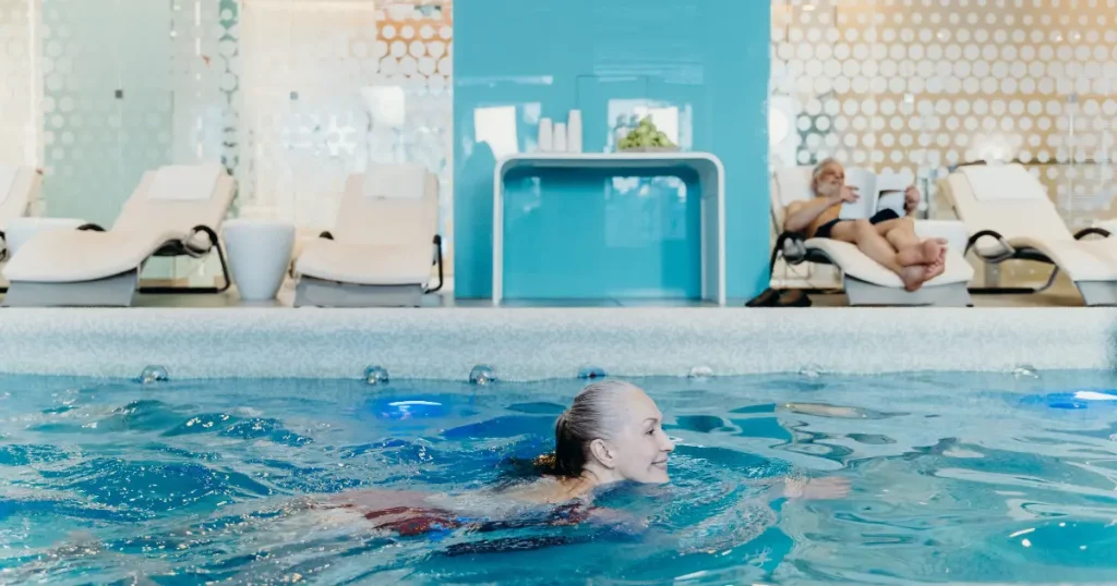 Older woman swimming in an indoor pool — illustrative recreation for an all-inclusive family vacation east coast.